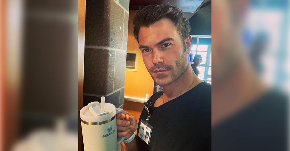 Male nurse in nursing school holds cup