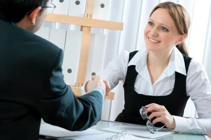 female and male shaking hands in office setting