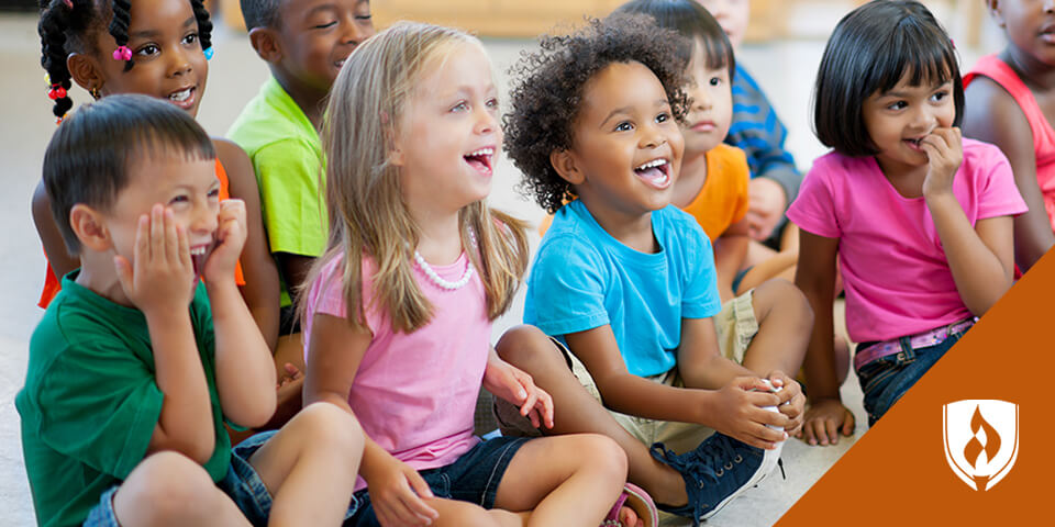 group of preschool children sitting on floor laughing