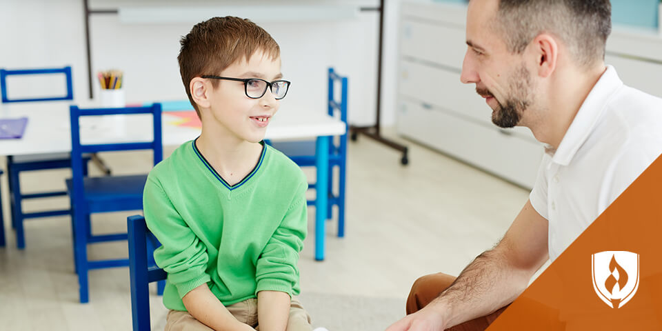 young boy talking to male teacher