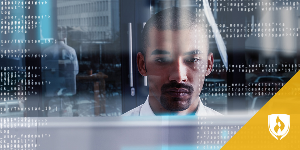 man sitting in front of computer looking at information on screen