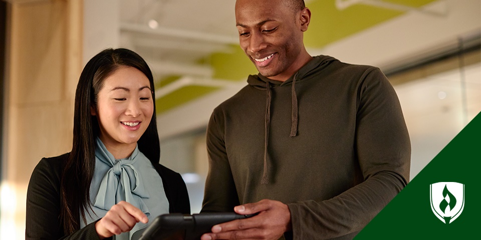 photo of an it project manager showing a coworker something on a tablet