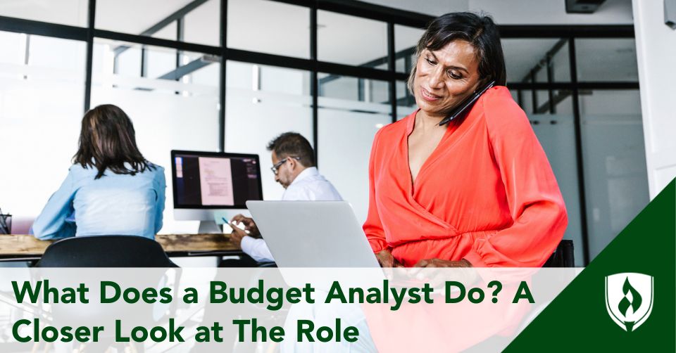 A budget analyst with a computer and phone in a shared office space