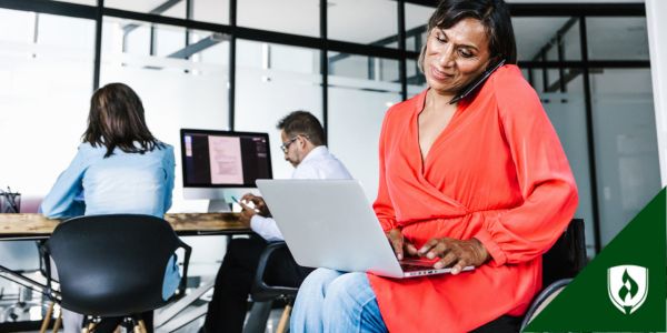 A budget analyst with a computer and phone in a shared office space