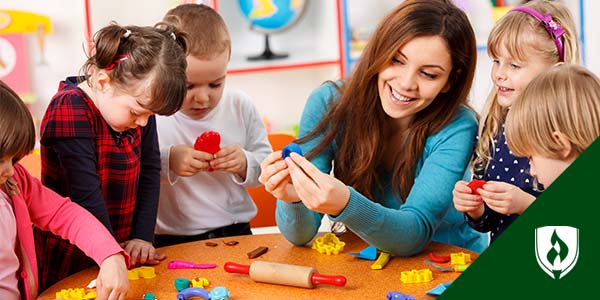 Photo of an early childhood educator working with a group of children.