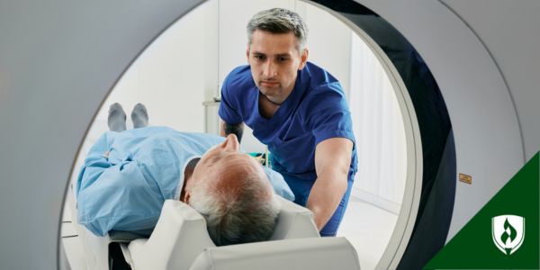 A radiology tech helps a patient get into an imaging machine