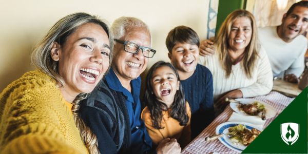 A happy family laughs around a dinner table