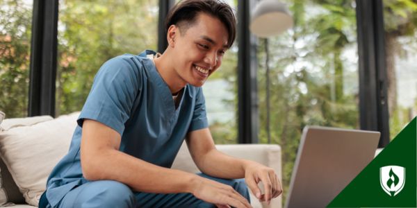 A nursing graduate looks at a computer, waiting on his NCLEX result