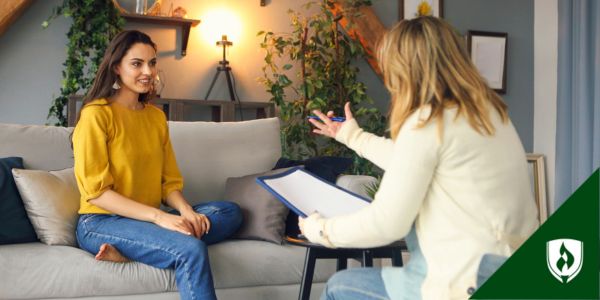 A holistic nurse meets with a patient in a room with greenery