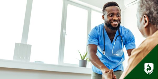 A mental health nurse smiles at his elderly patient