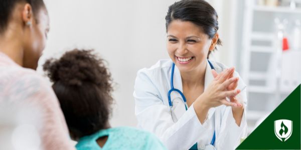 A family nurse practitioner laughs with two patients