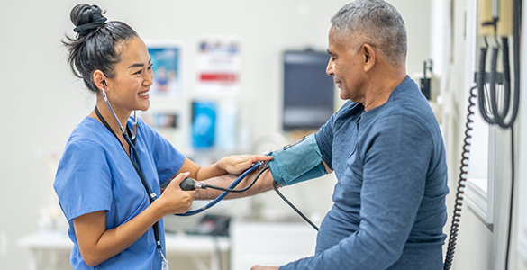 Medical assistant taking blood pressure of a male patient